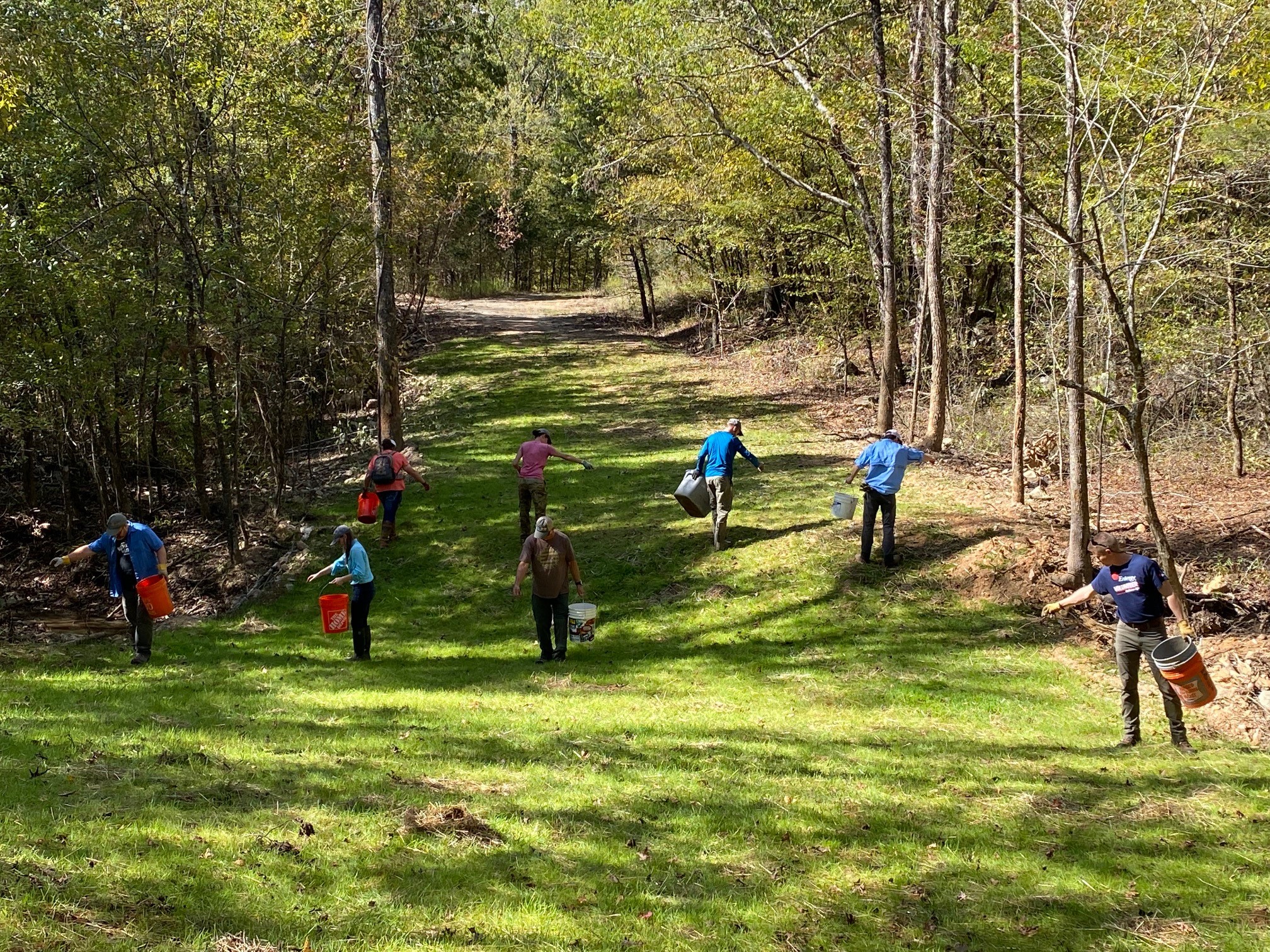 Entergy Arkansas' David Wasson (far right) and other volunteers plant native seeds along the new river channel.